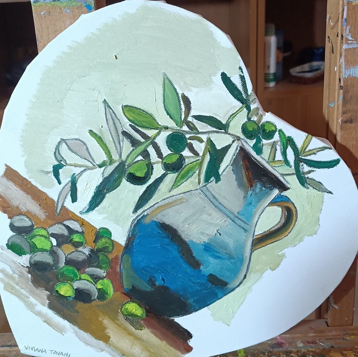 Heart-shaped canvas with an olive branch, olives and a blue pitcher. Oil on canvas.